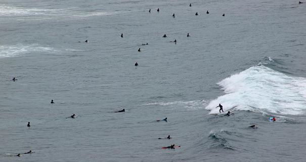 Surfers voor het strand van Praia da Amado
