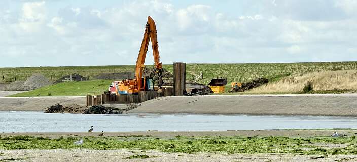 Hier graaft men een zeewater doorgang voor de achterliggende polder, daarom was de weg afgesloten
